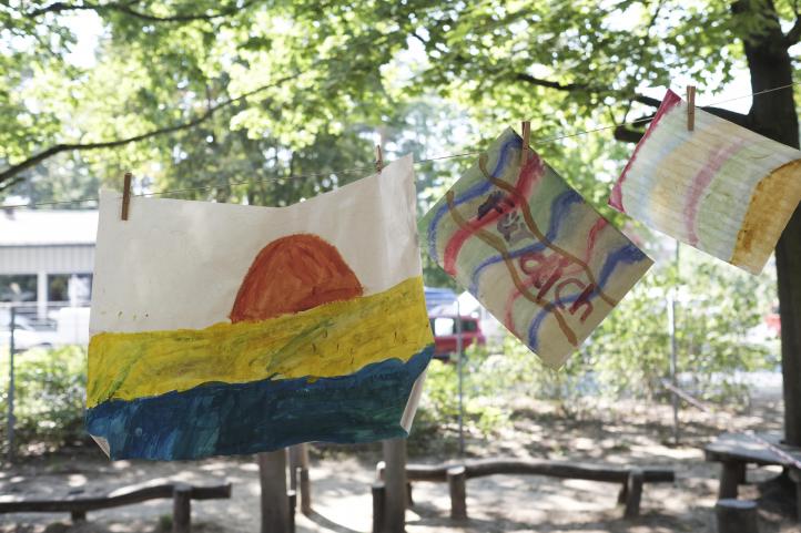 Getuschte bunte Kinderbilder sind zum Trocknen auf einer Wäscheleine aufgehängt