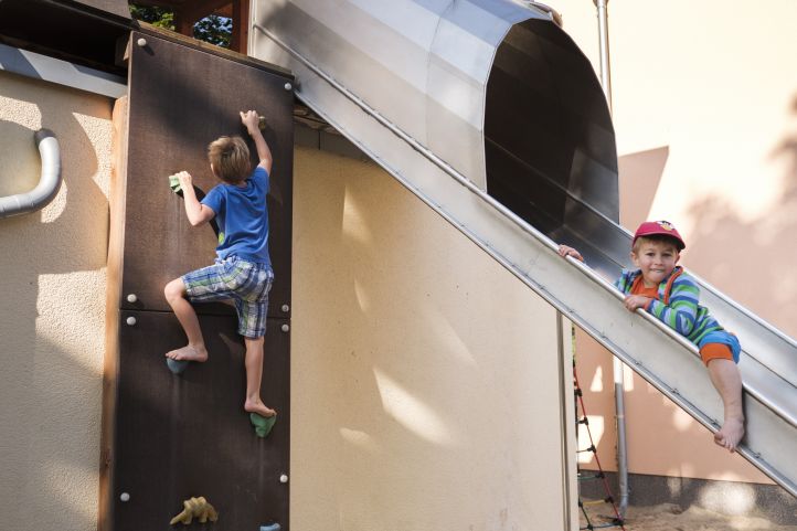 Jungen spielen auf einer Rutsche