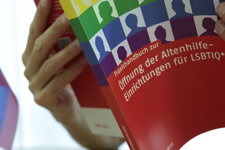 Person hält das Praxishandbuch in den Händen
