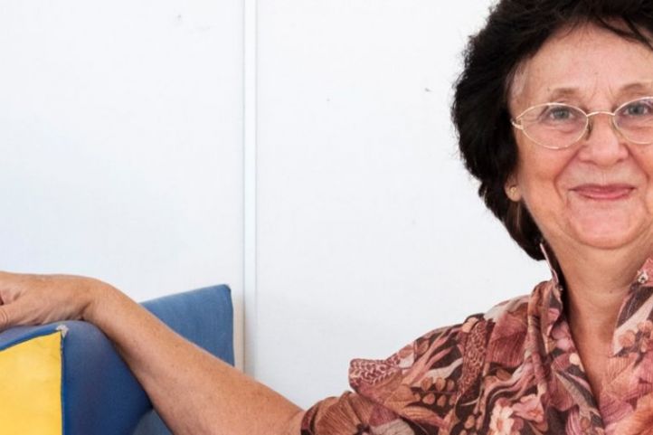 Eine Frau mittleren Alters lächelt engagiert in die Kamera.