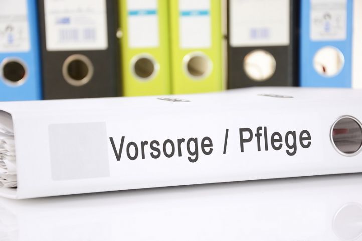 Liegender weißer Ordnungshefter mit Aufschrift Vorsorge Pflege