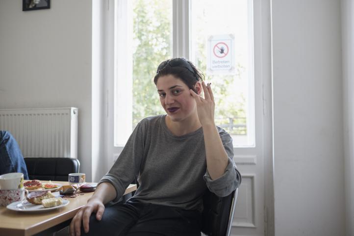 Eine an einem Tisch sitzende Frau raucht