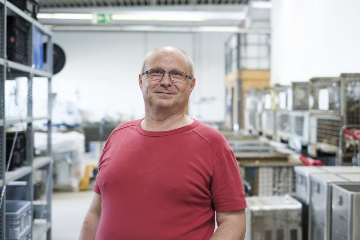 Ein Mann im roten Shirt lächelt