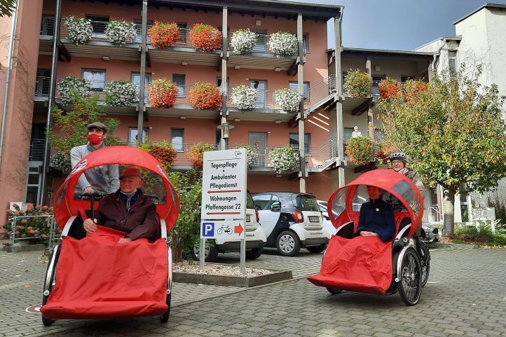 Vier Personen fahren über einen Parkplatz