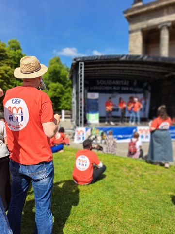 Rückensansicht von Menschen mit Crew-Shirt vor der Bühne bei der 100 Boote Aktion im Lustgarten Berlin