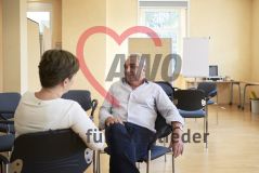 Zwei Personen unterhalten sich in einem Seminarraum